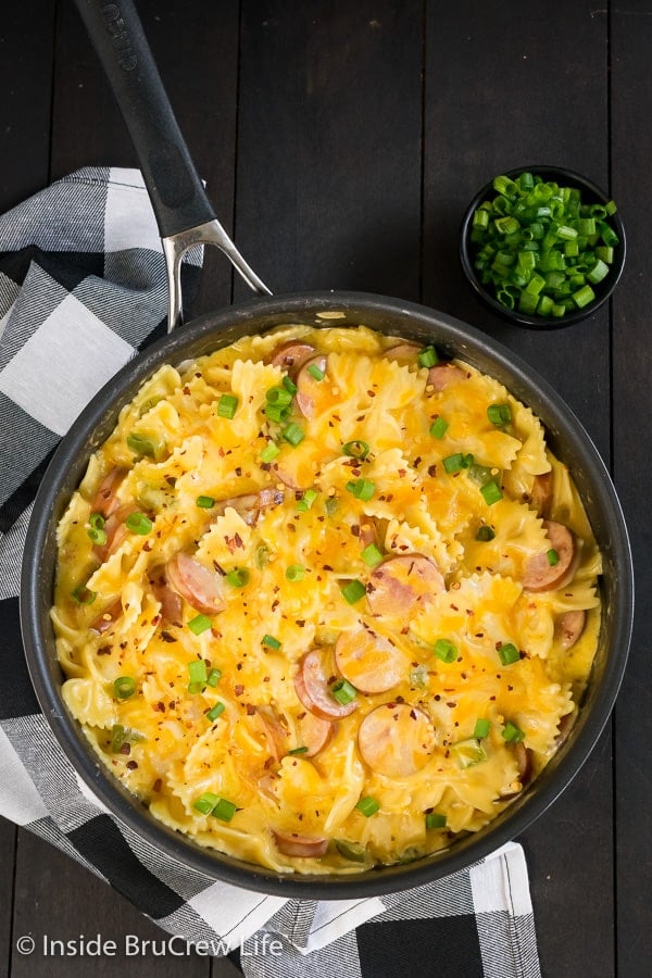 Overhead picture of a skillet full of cheesy pasta on a dark board