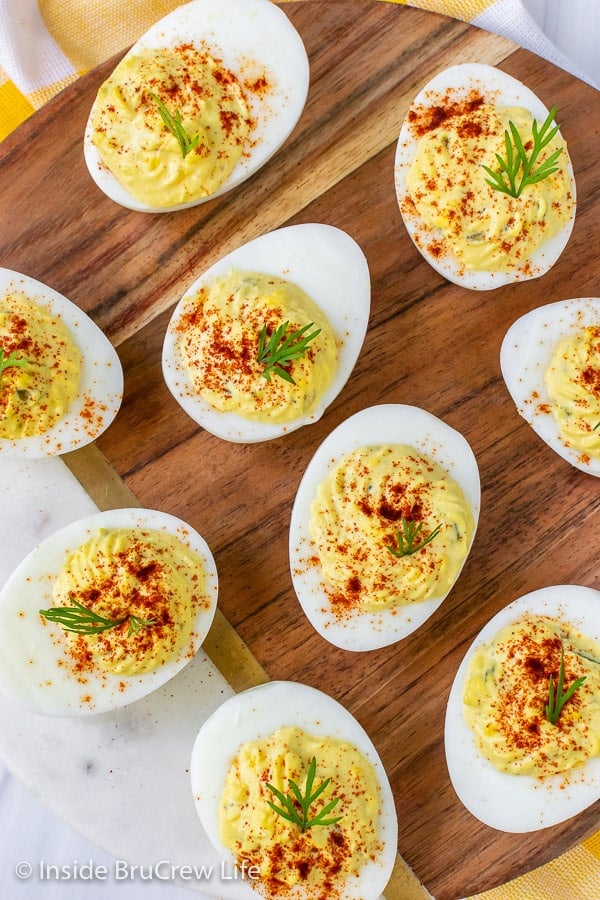Overhead picture of deviled eggs on a white and brown serving tray
