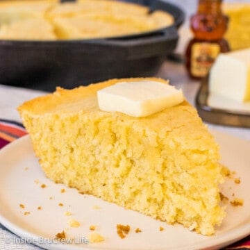 Square photo of a wedge of easy skillet cornbread on an off white plate