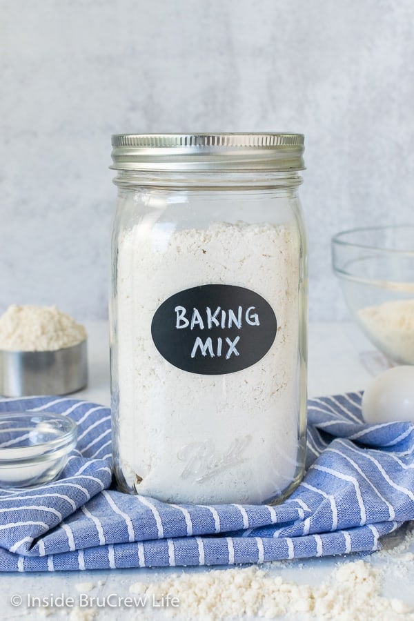 A large Mason jar on a blue towel filled with homemade baking mix.