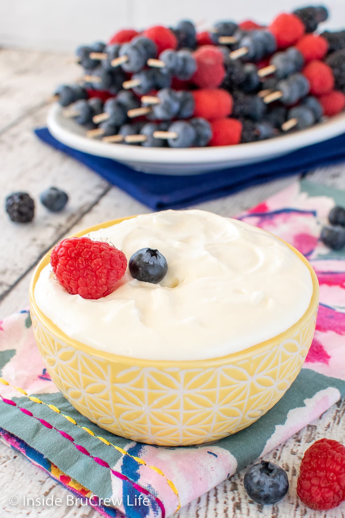 A bowl of fruit dip and a plate of fruit.