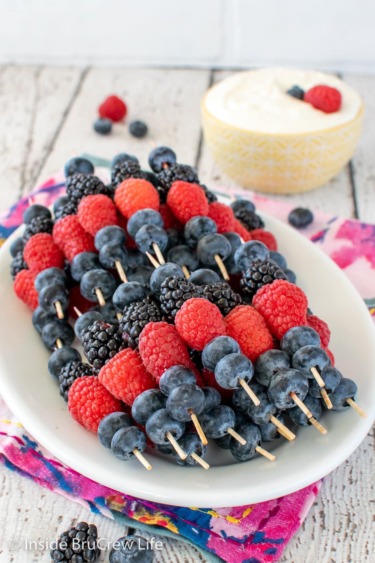 Fruit skewers on a white plate.