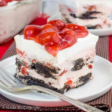 A white plate with a square of cherry Oreo icebox cake on it and cherry pie filling on top