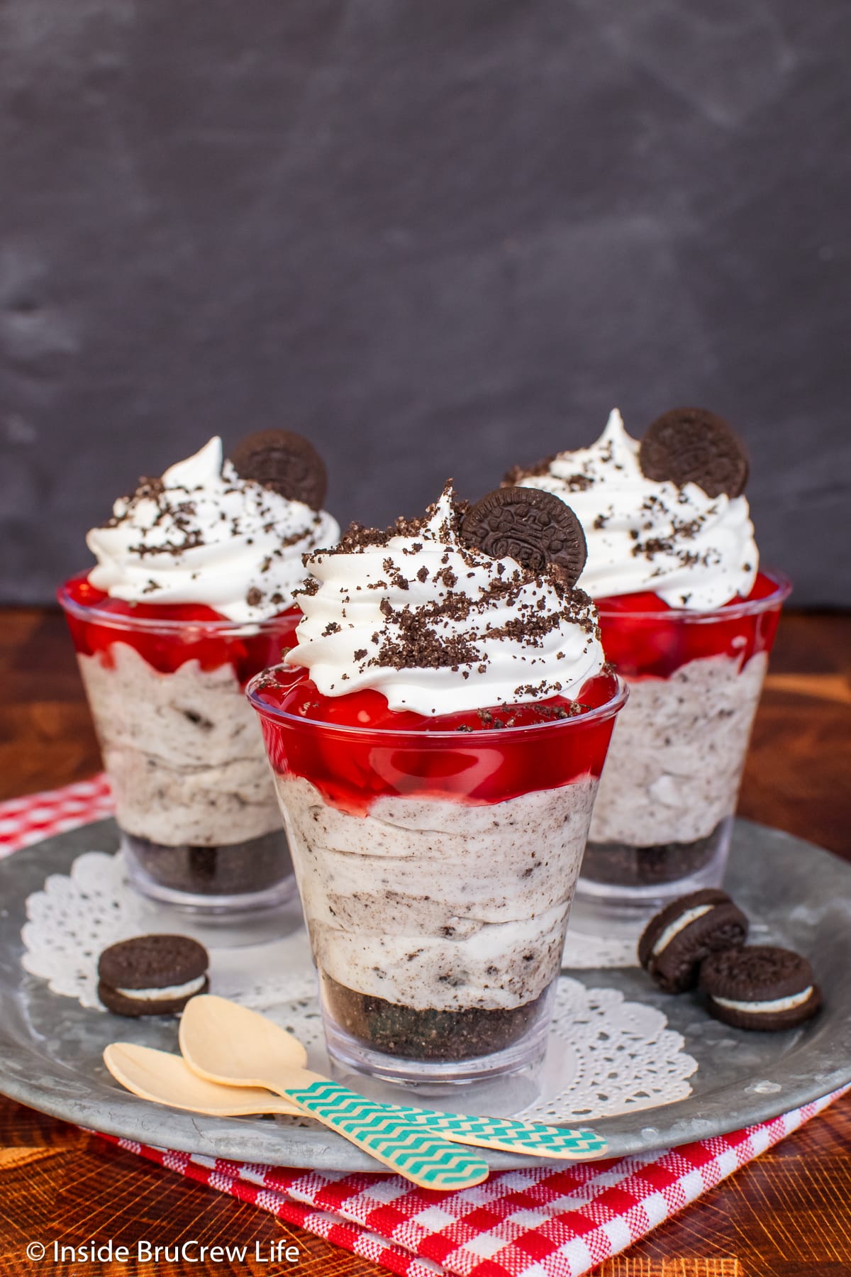 Three Oreo parfaits topped with cherry pie filling.