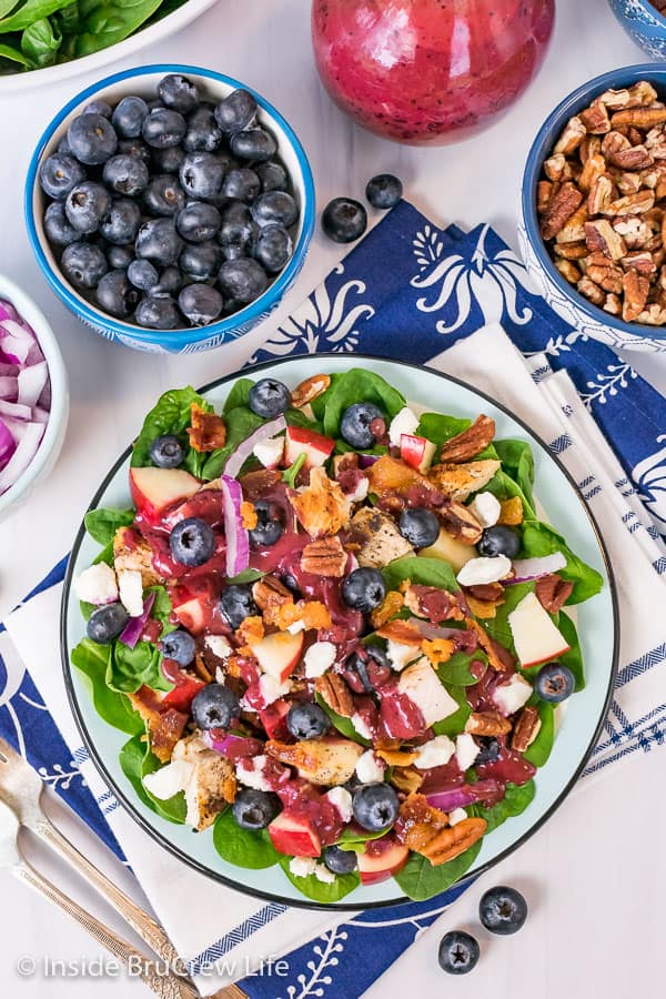 An overhead picture of a plate of spinach salad drizzled with Blueberry Balsamic Salad Dressing.