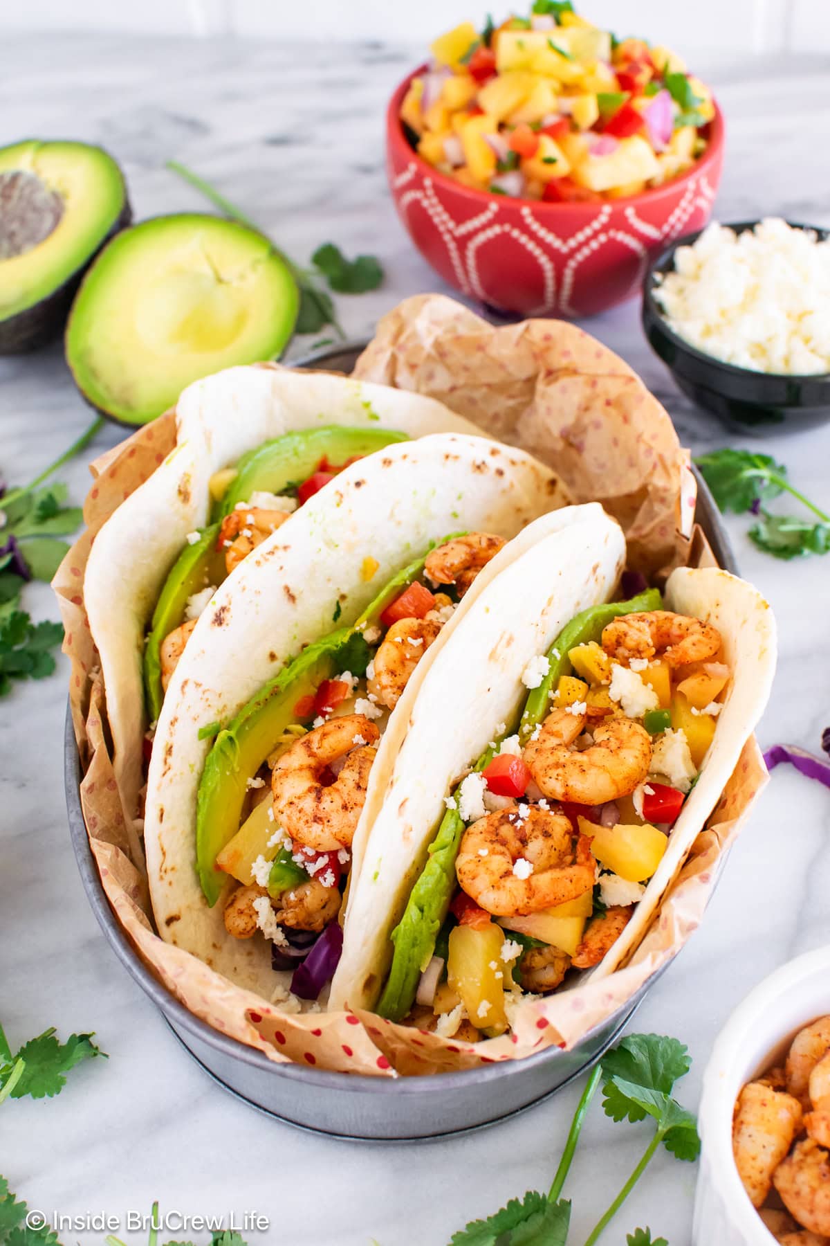 Three flour tortillas filled with jerk shrimp and toppings.