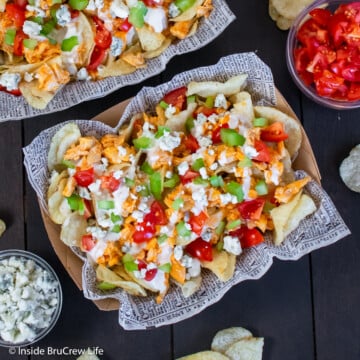 Spicy chicken and toppings over chips in a bowl.