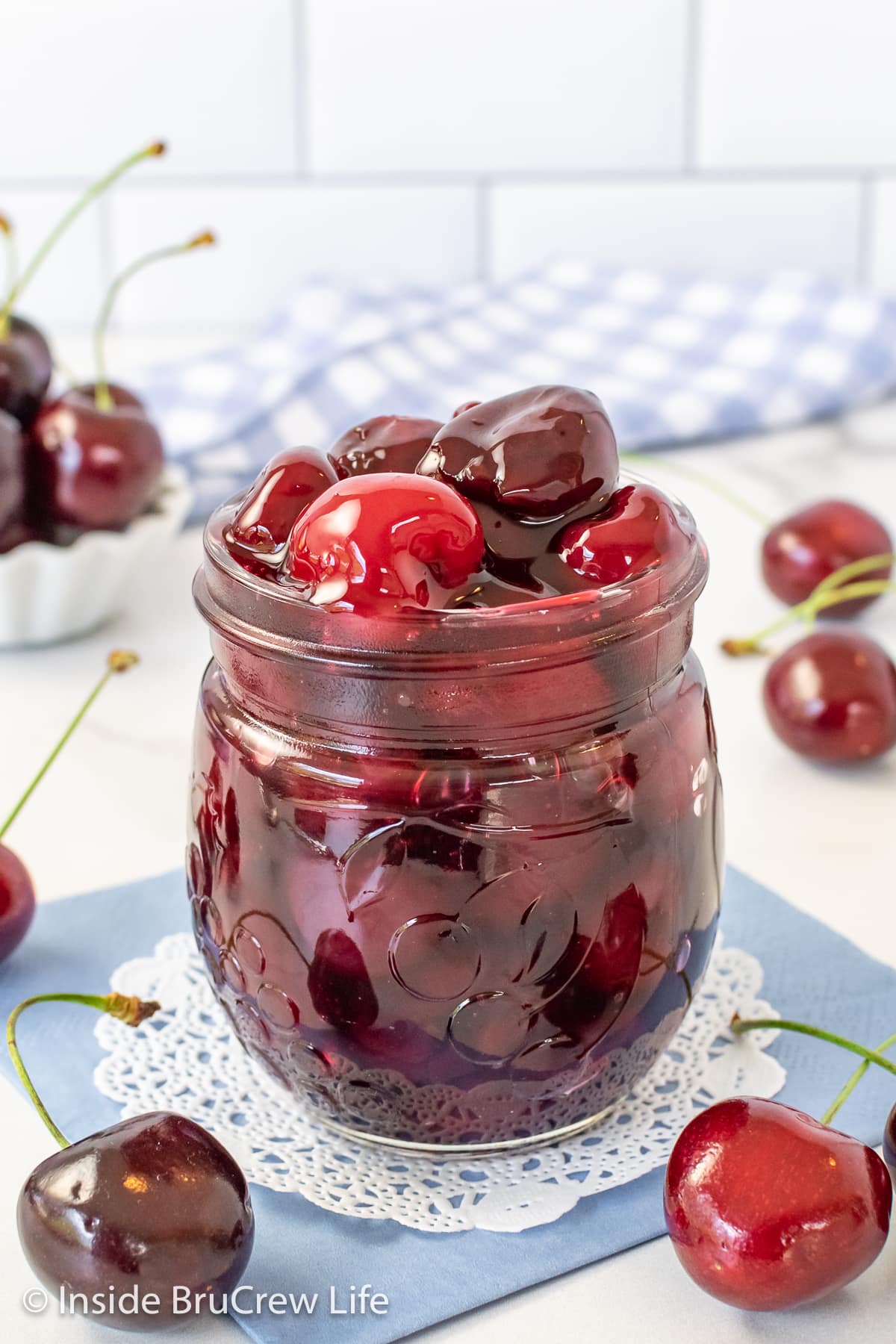 A clear jar filled with homemade pie filling made with fresh cherries.