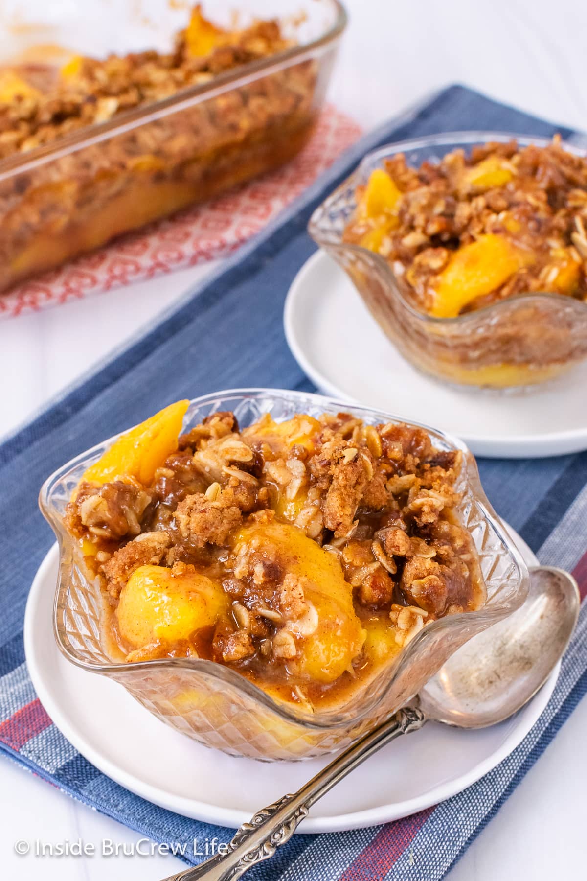 Two bowls of peaches and crispy oat topping.