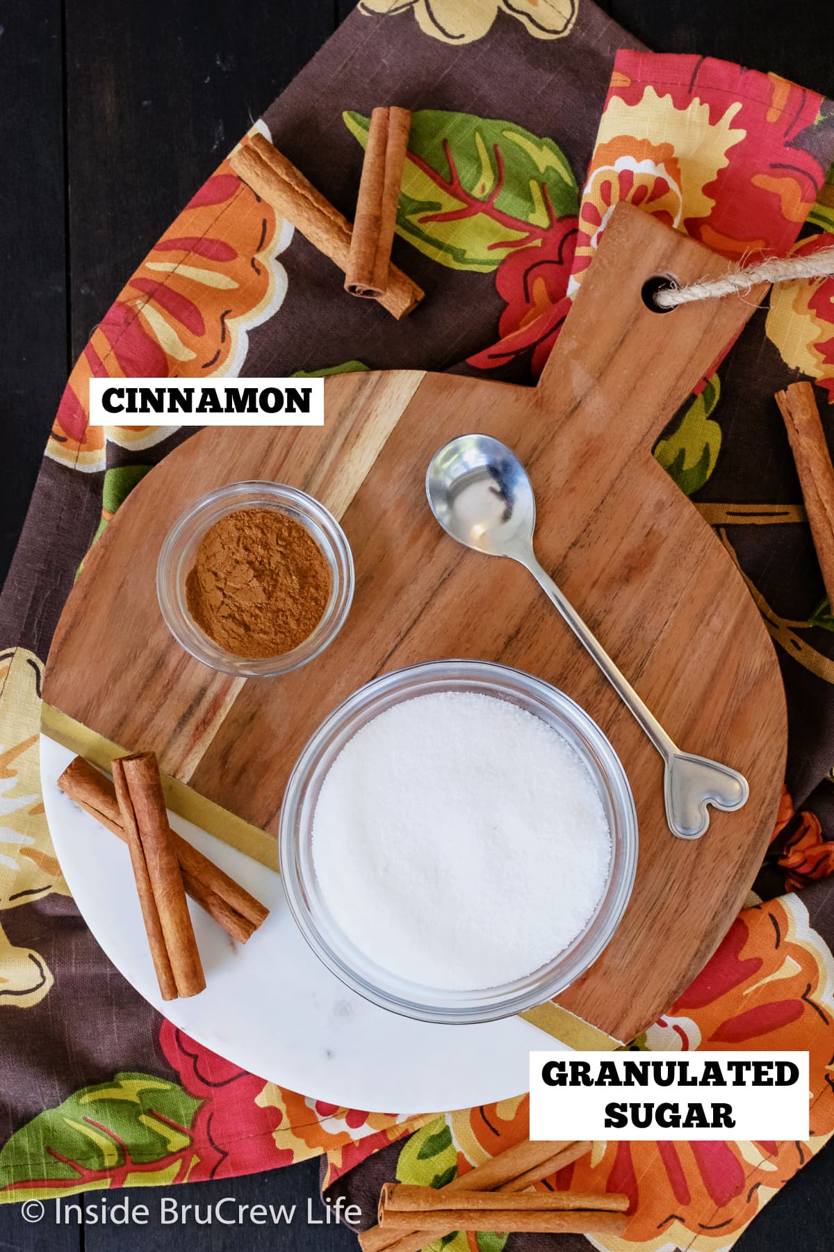 A round board with bowls of cinnamon and sugar in them.