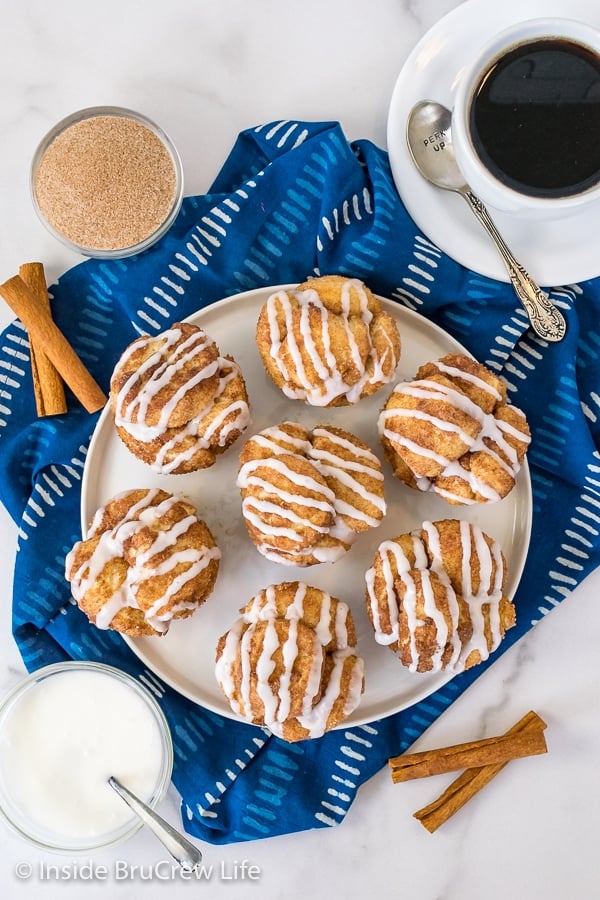 Overhead picture of a white plate with glazed monkey bread muffins on it and coffee beside it