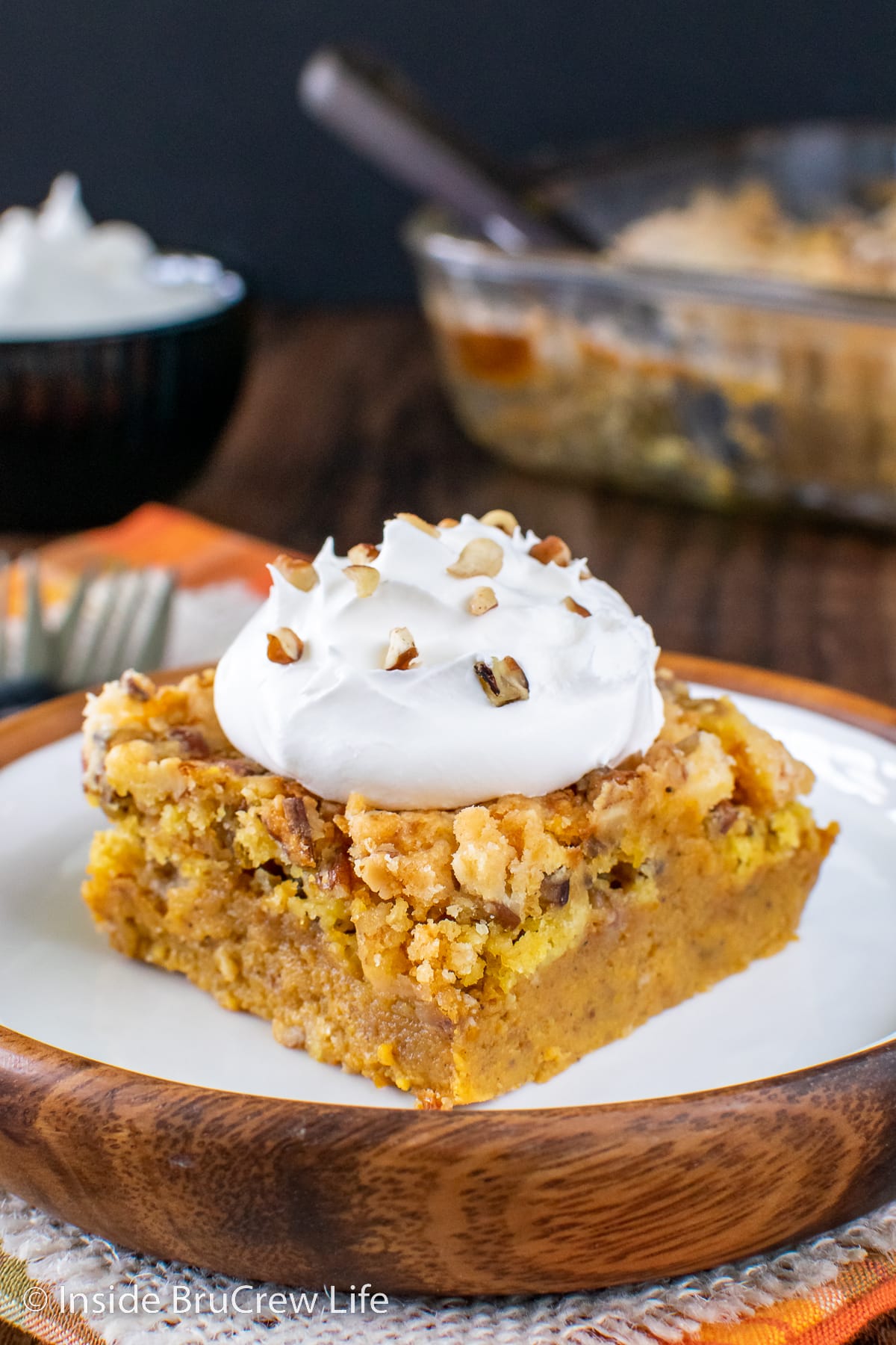 Pumpkin cobbler square on a white plate with Cool Whip.