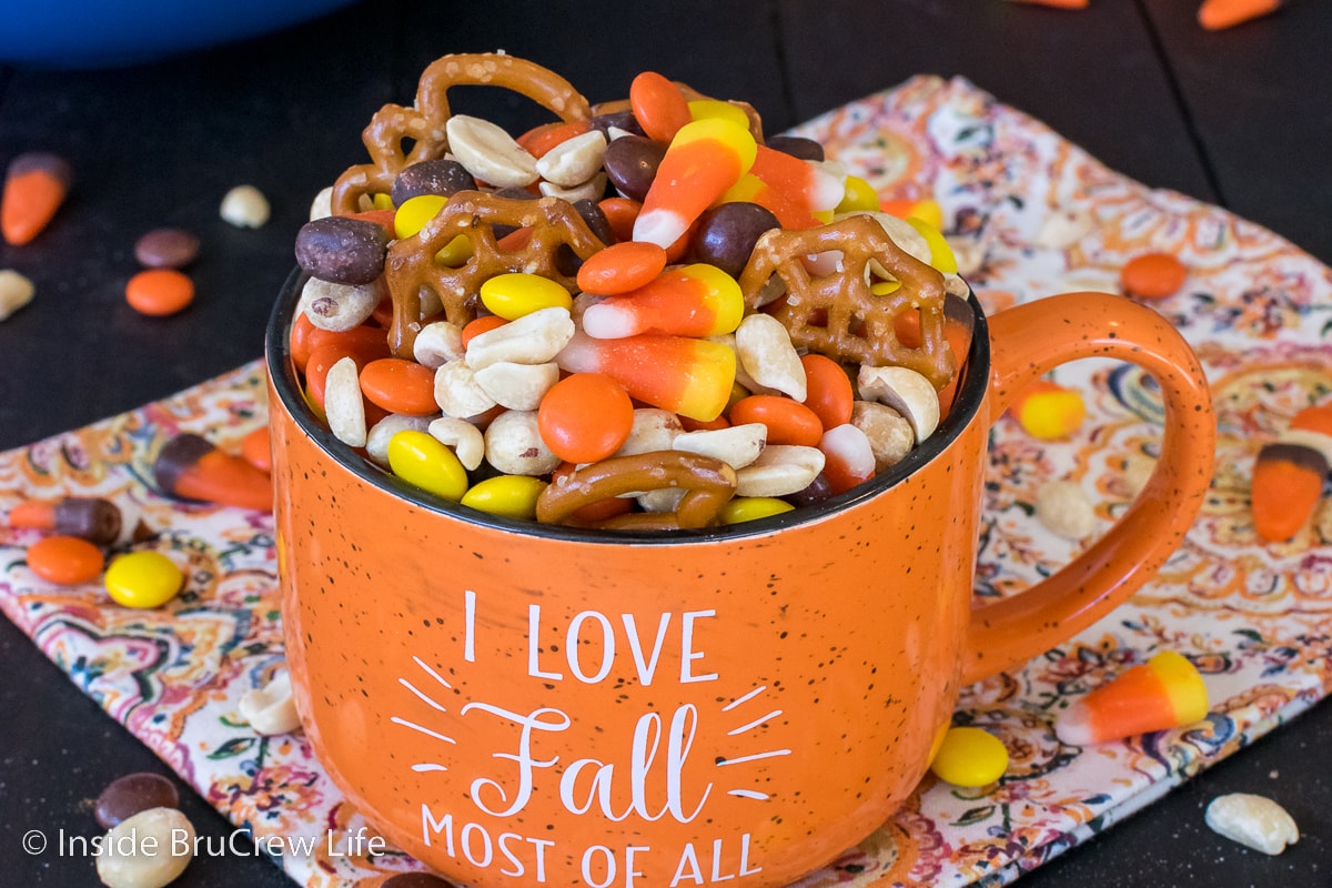 An orange cup filled with candy corn mix.