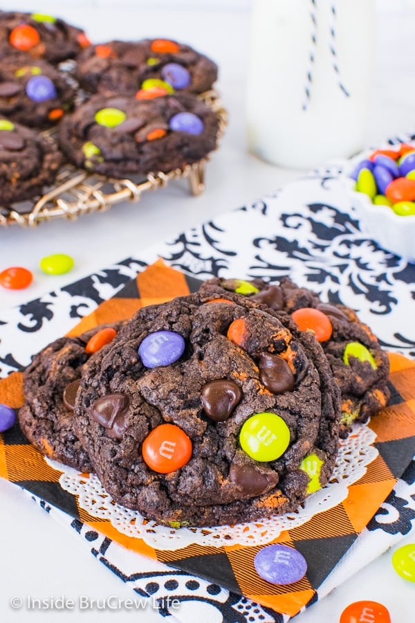 A close up of chocolate cookies and cream cookies topped with Halloween candies with more cookies behind it