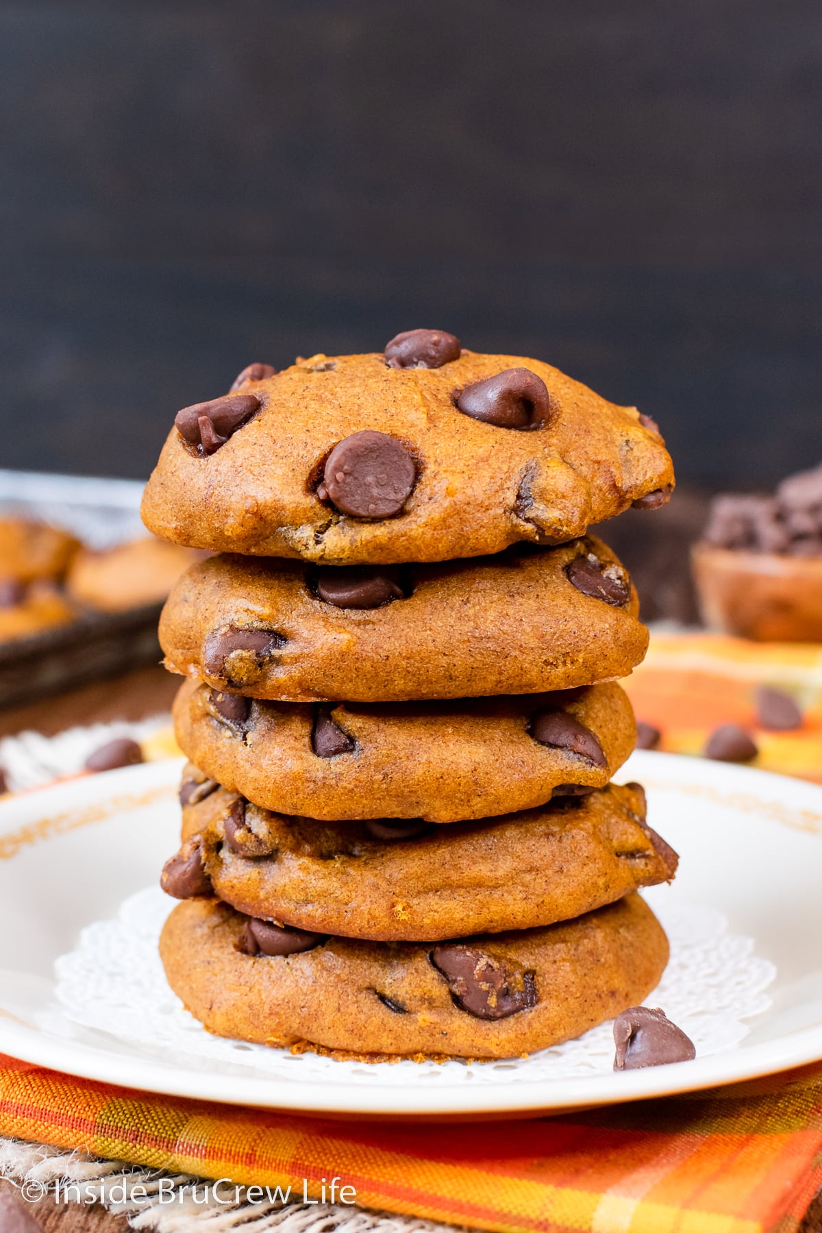 A stack of orange pumpkin cookies on a white plate.