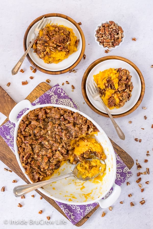 Overhead picture of a white casserole dish and two white plates with sweet potato souffle on it