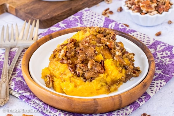 A scoop of sweet potato souffle on a white and brown plate