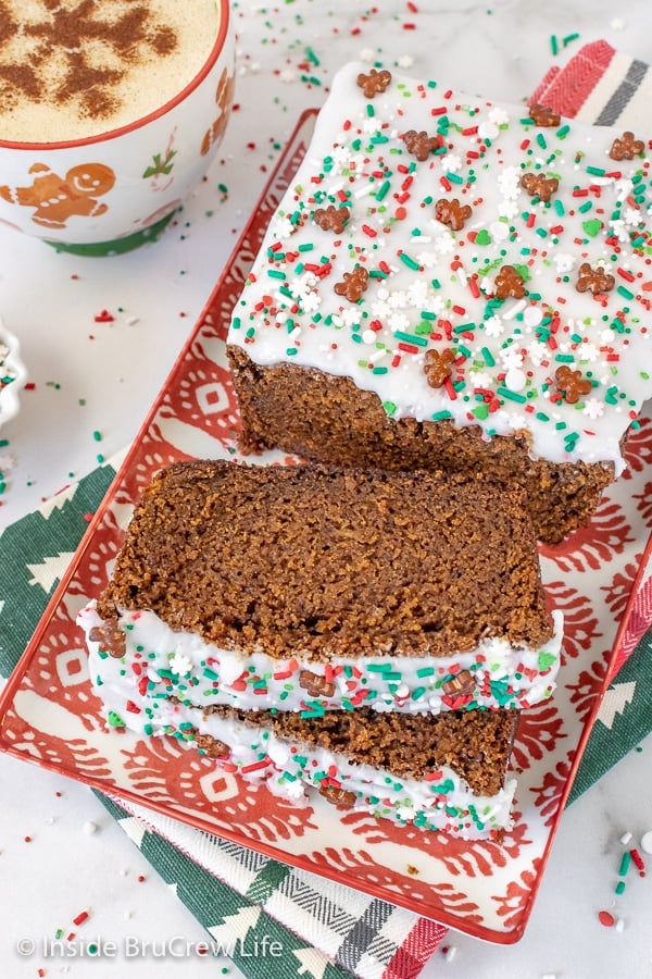 Overhead picture of a plate with a loaf of gingerbread banana bread and a few slices lying down on it.