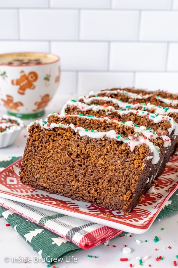 A red and white plate with slices of banana bread standing on it and a cup of coffee behind it.