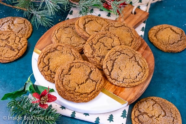 Overhead picture of a round tray with molasses crackle cookies stacked and scattered on it