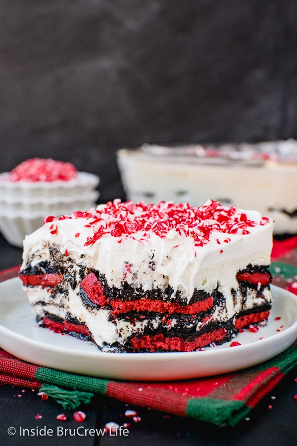 A white plate with a piece of peppermint oreo icebox cake on it with a bite taken out of the front