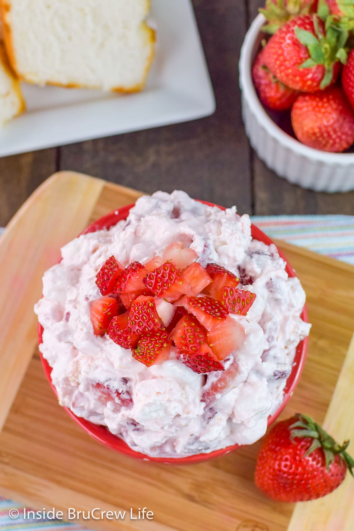 Overhead picture of a red bowl filled with a pink dessert salad.