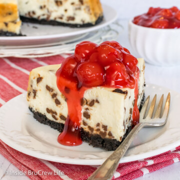 A slice of cheesecake topped with cherry pie filling.