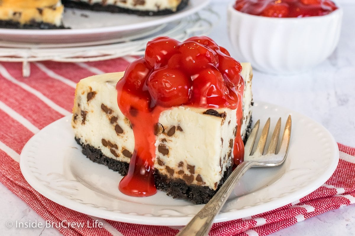 A slice of cheesecake topped with cherry pie filling.