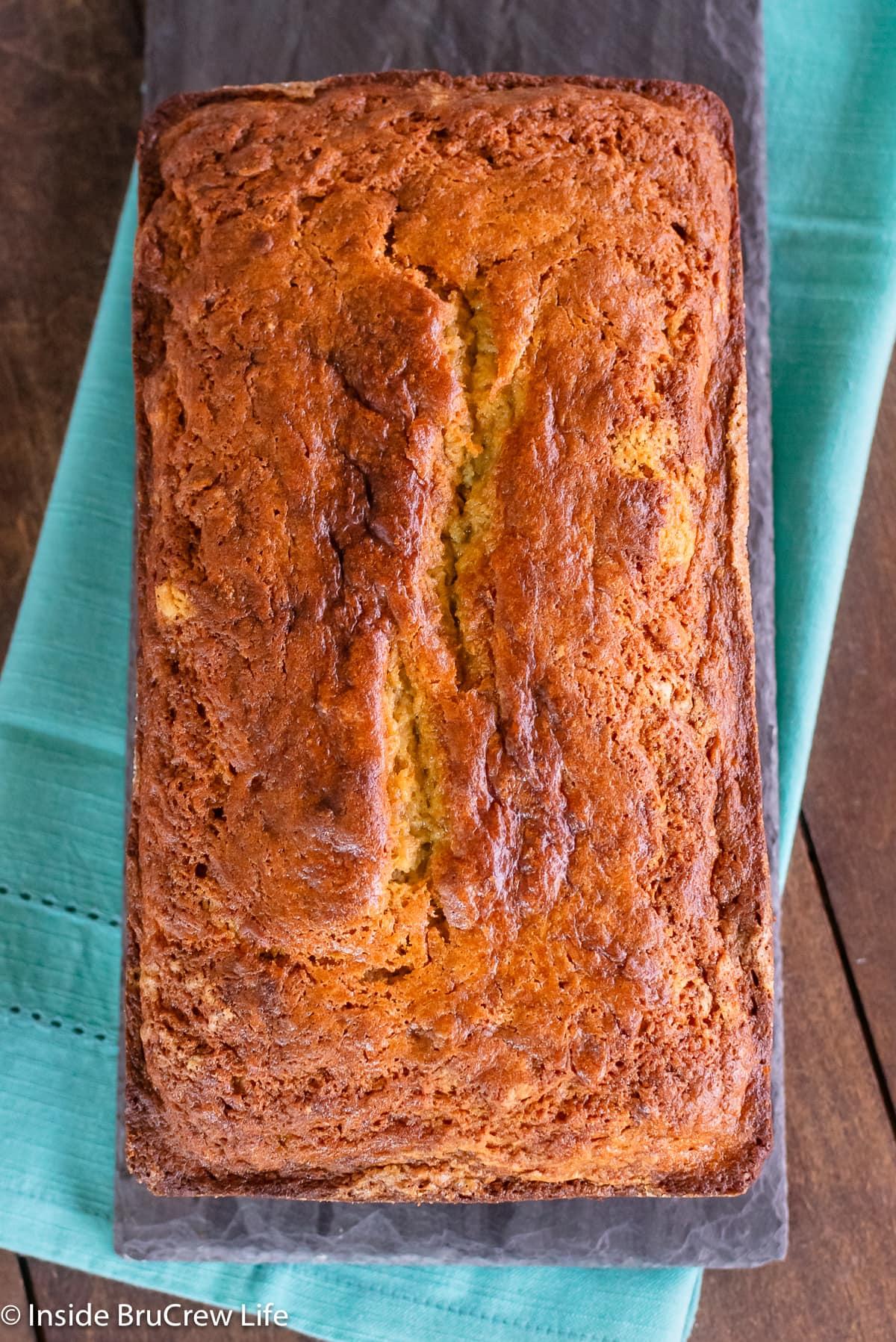 A loaf of quick bread on a dark board.