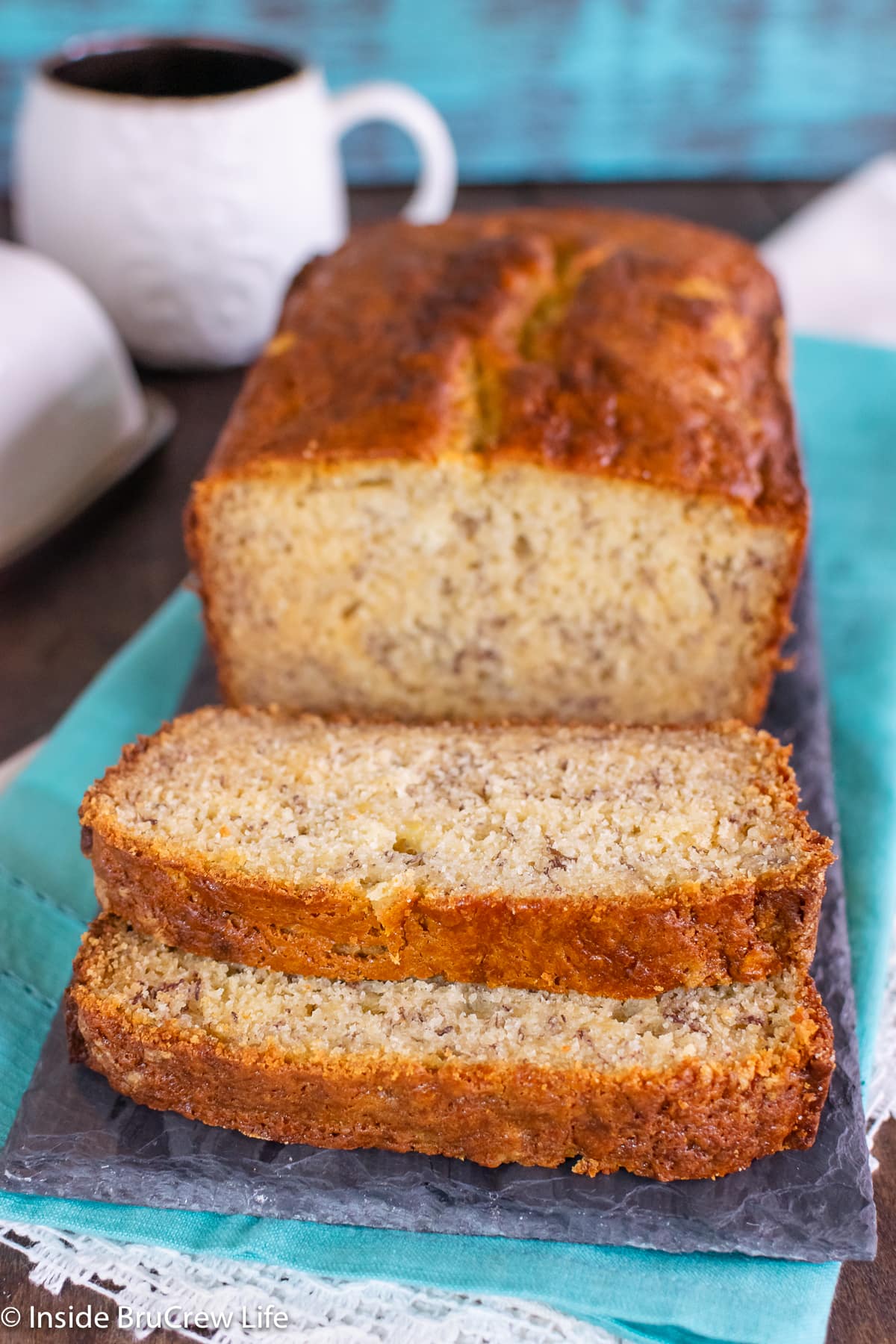 A cut loaf of sweet bread on a dark tray.