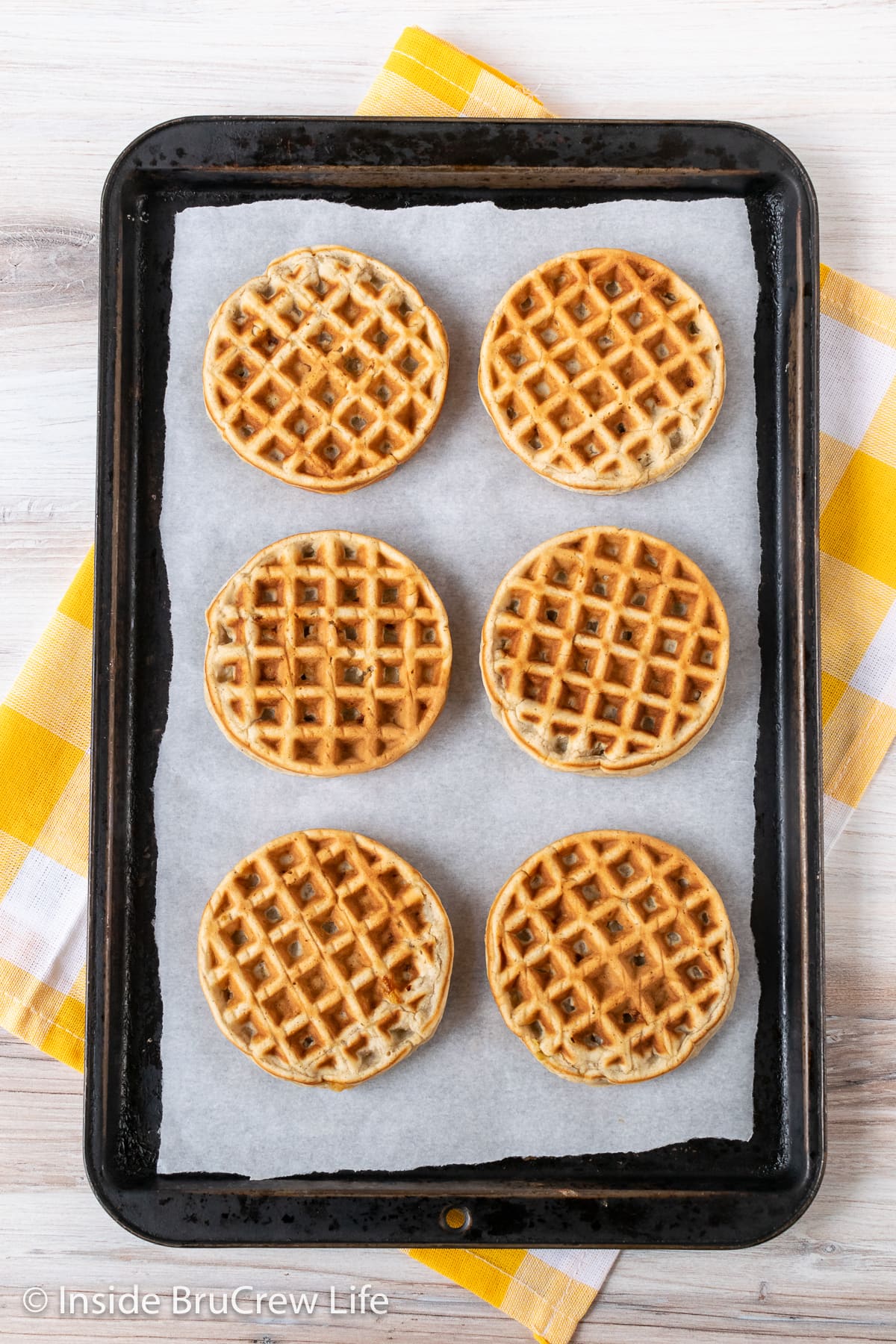 Round waffles on a lined baking sheet.