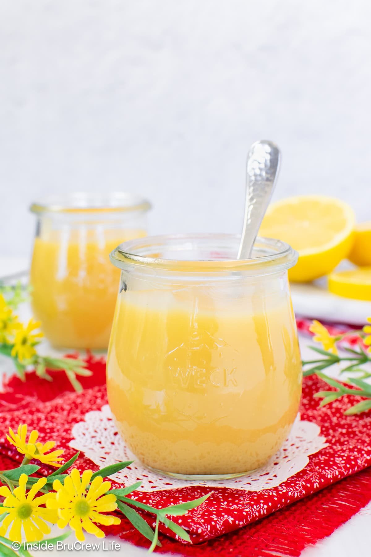 Two jars filled with easy lemon curd and spoons.