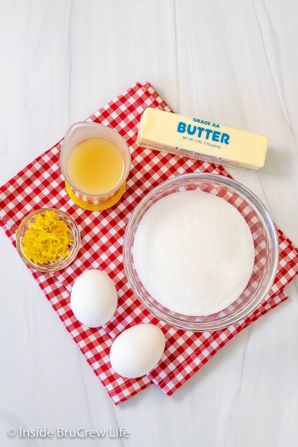 A red and white checkered towel with bowls of ingredients needed for making an easy homemade lemon curd