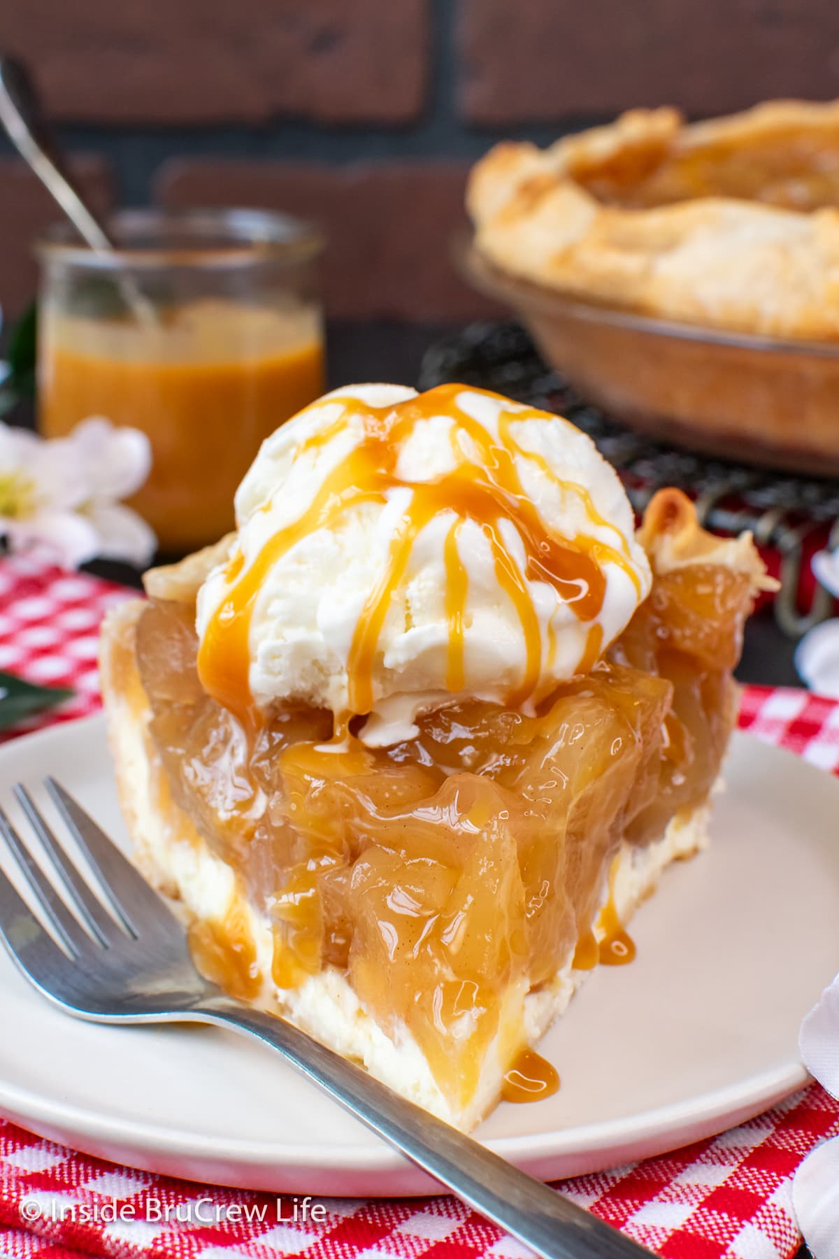 A slice of pie on a plate with a scoop of ice cream on top.