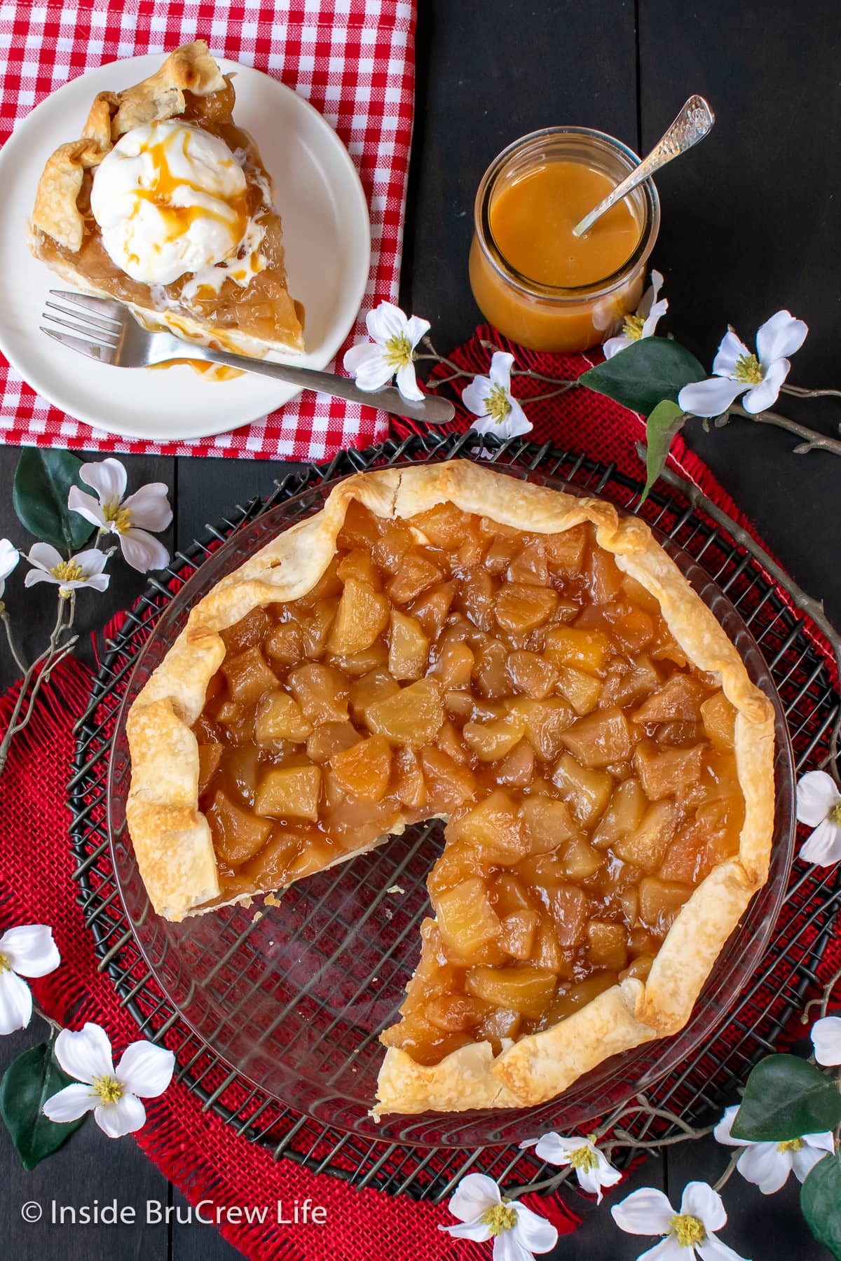 A rustic apple pie with one slice missing.