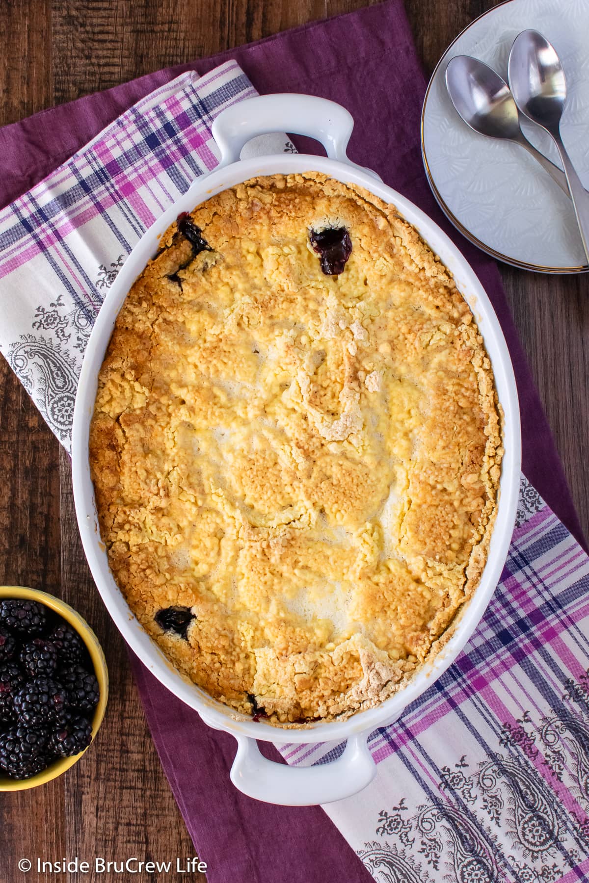 A white baking dish filled with baked cobbler.