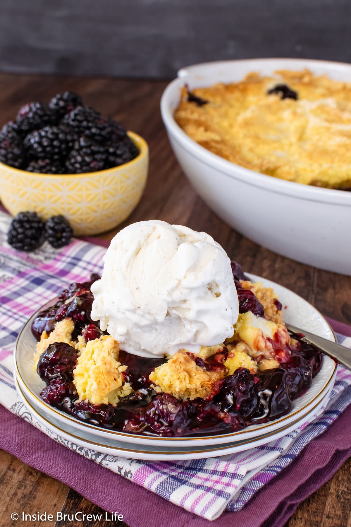 Fruit cobbler and ice cream on a white plate.