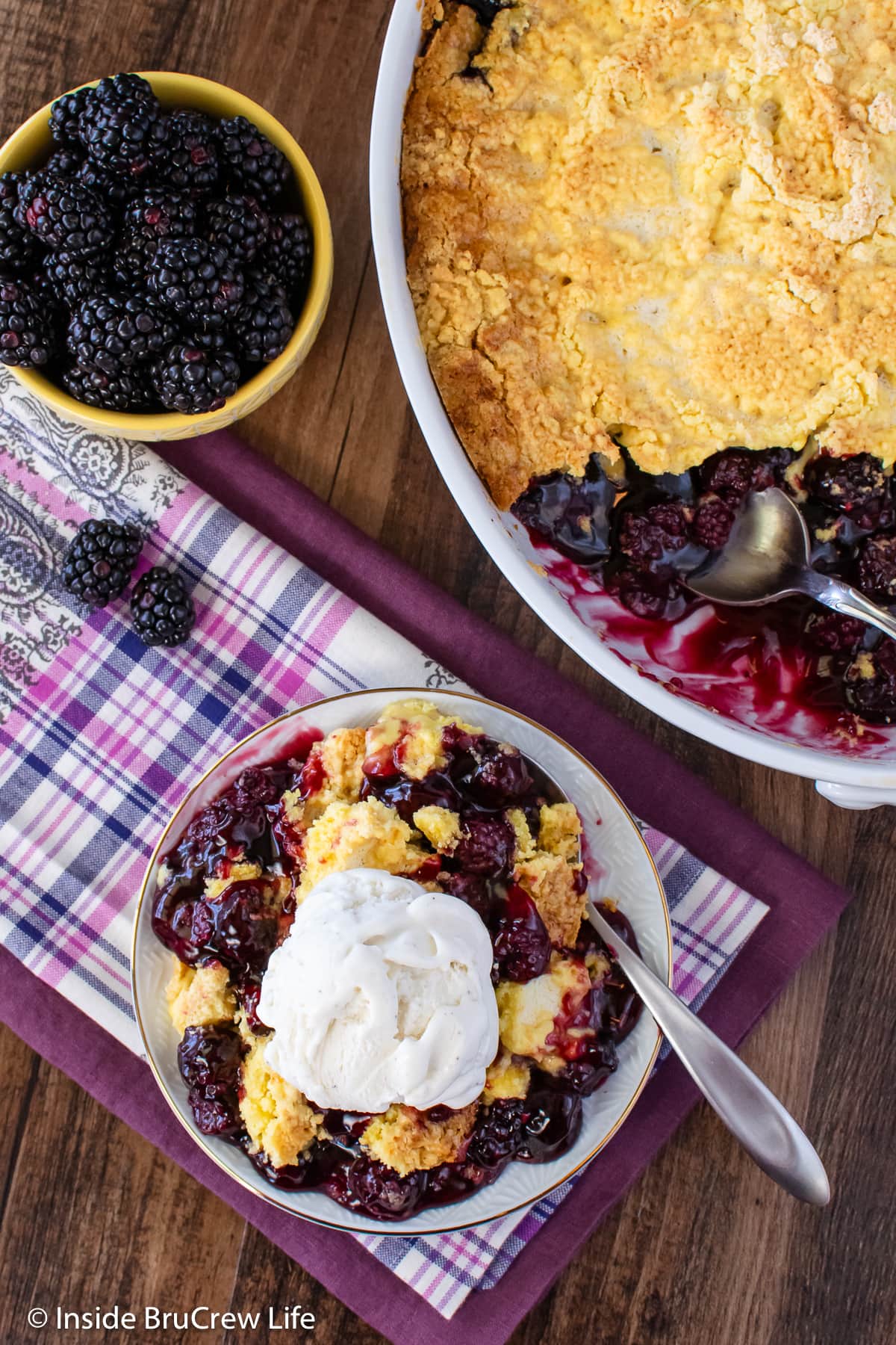 Overhead picture of a plate and baking dish with fruit cobbler in them.