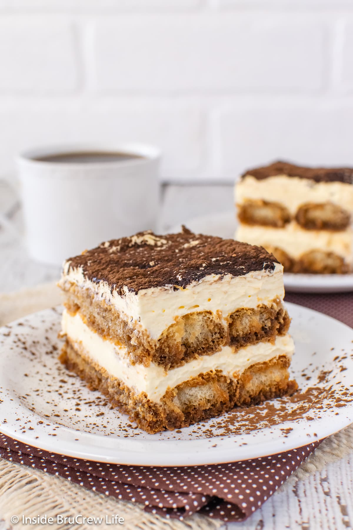 Two plates with squares of no bake coffee dessert on them.