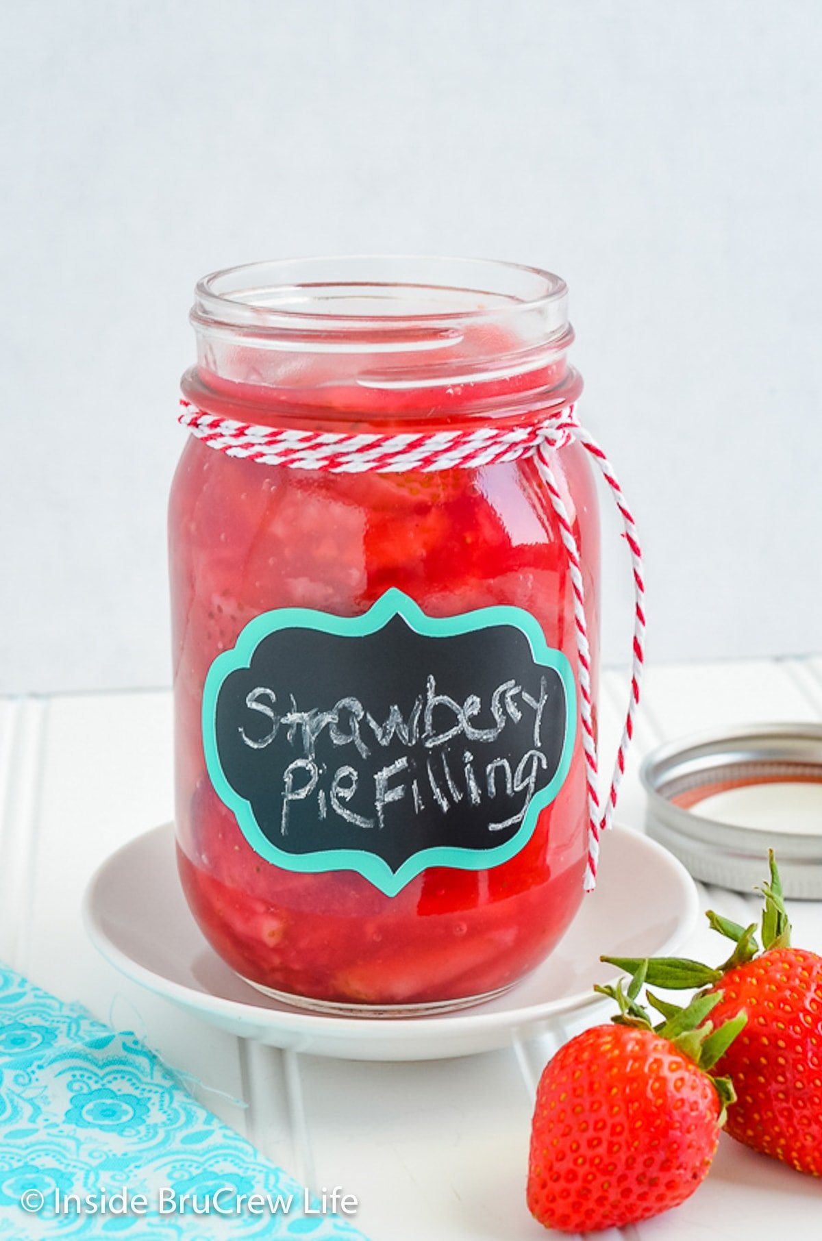 A clear Mason jar filled with homemade strawberry pie filling.