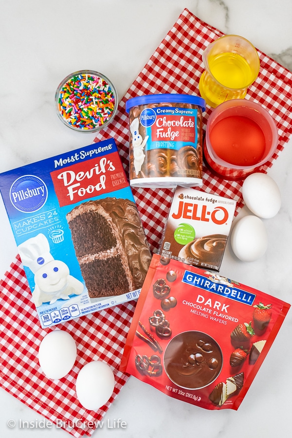 A white board with all the ingredients needed to make chocolate Mickey cake pops.