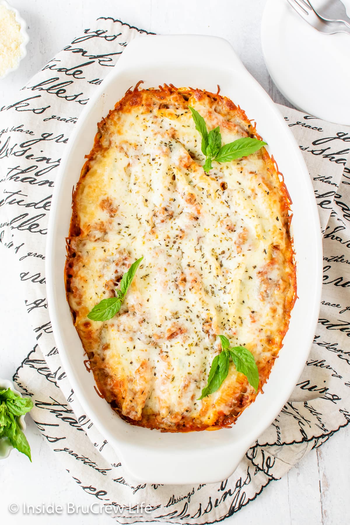 A white casserole dish filled with cheese and meat stuffed shells.