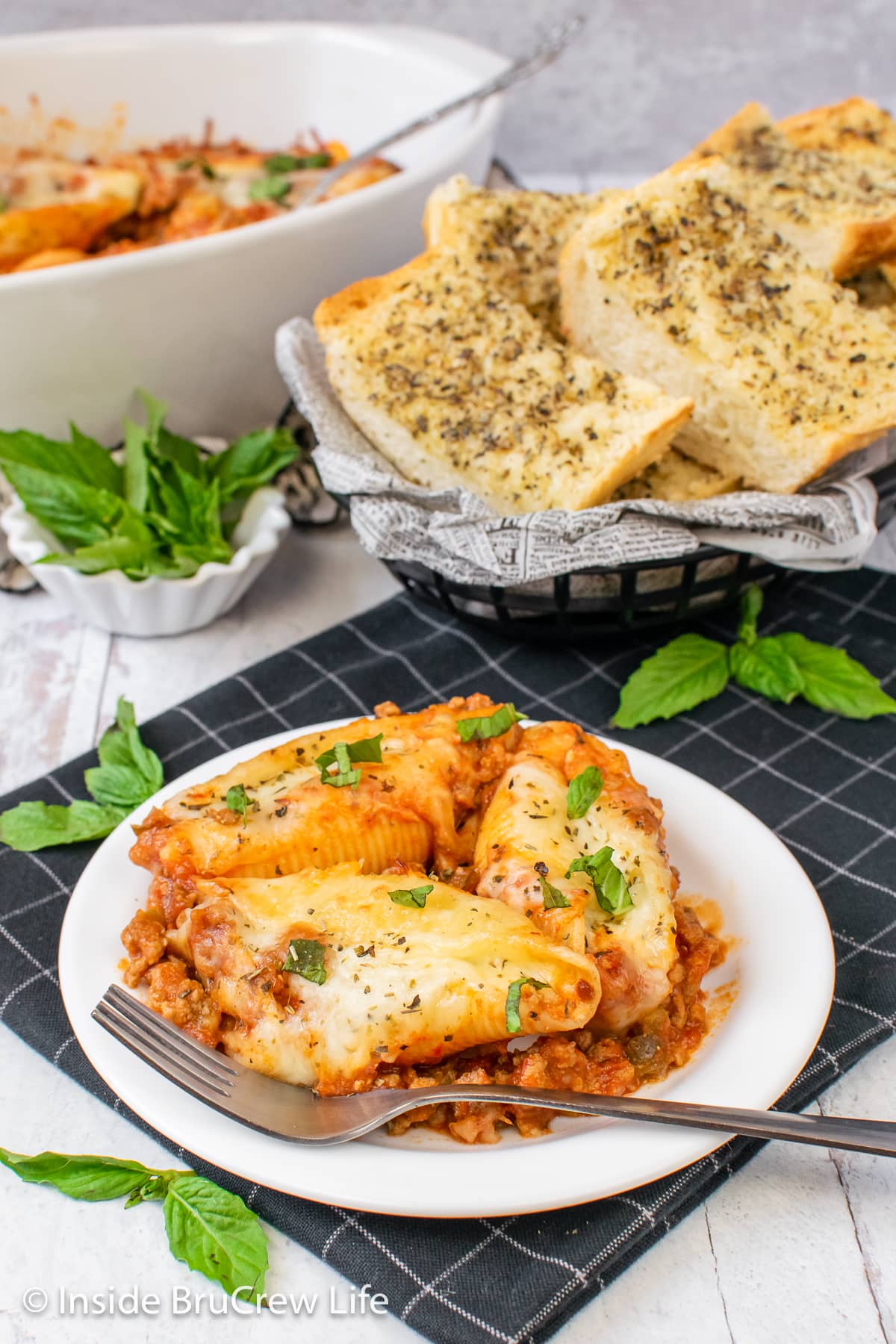 A white plate with three meat stuffed shells on it.