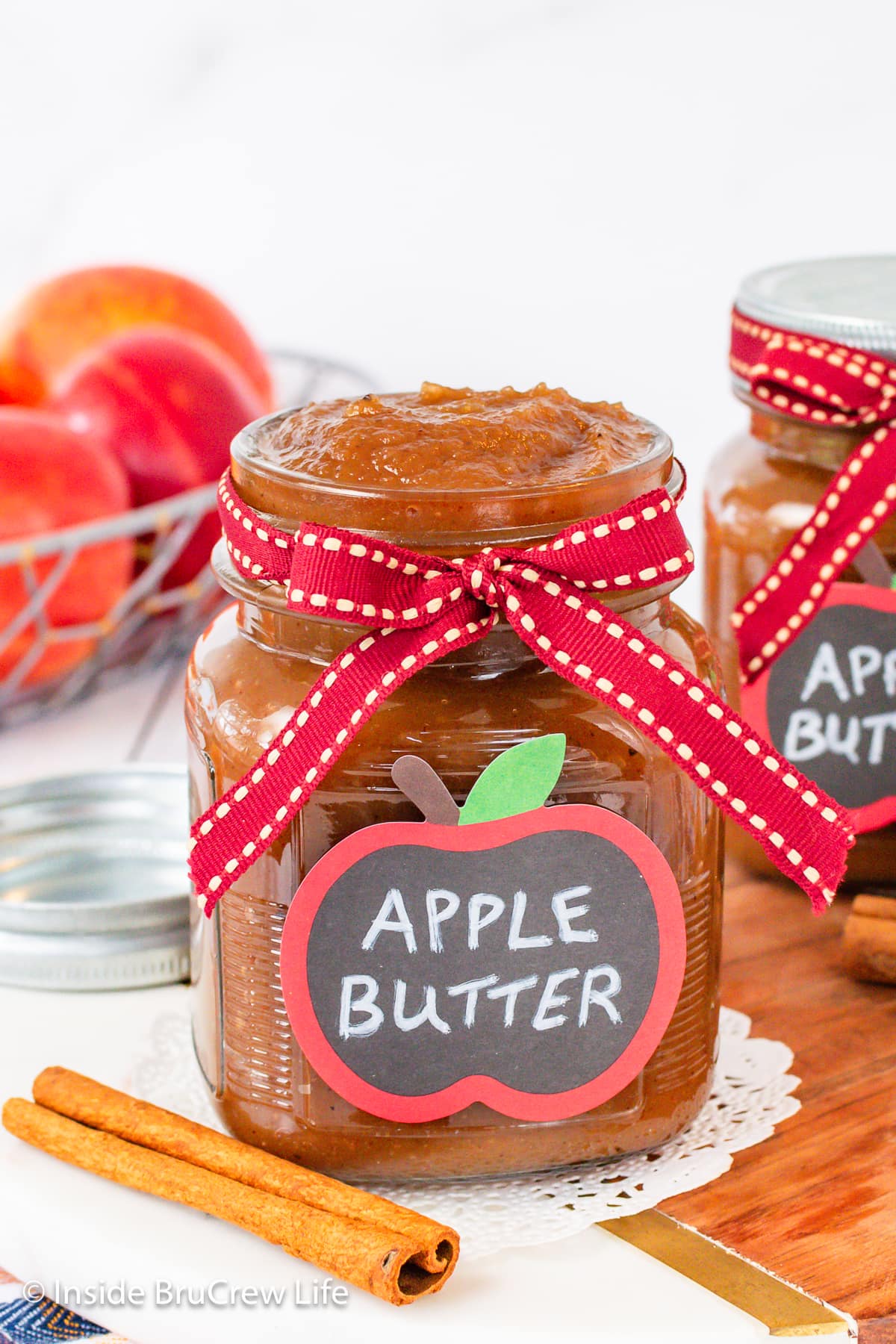 A clear jar with a ribbon filled with apple spread.