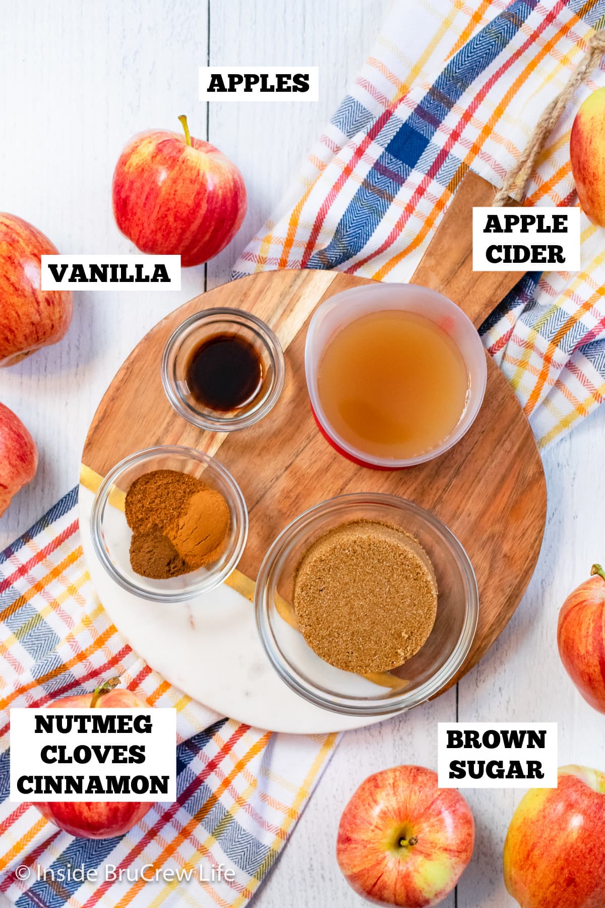 A white board with bowls of ingredients needed to make an apple spread.