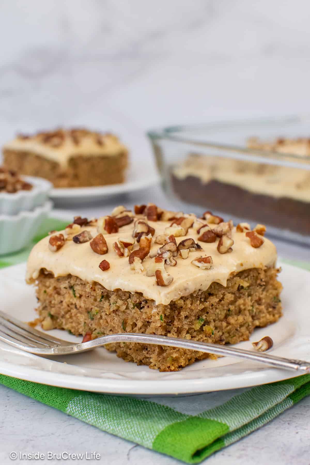 A square of banana zucchini cake on a white plate.