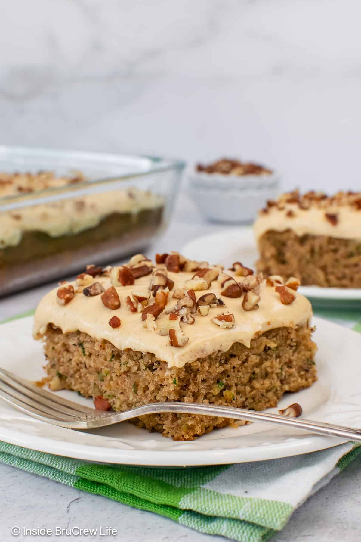 Two pieces of banana zucchini cake on white plates.