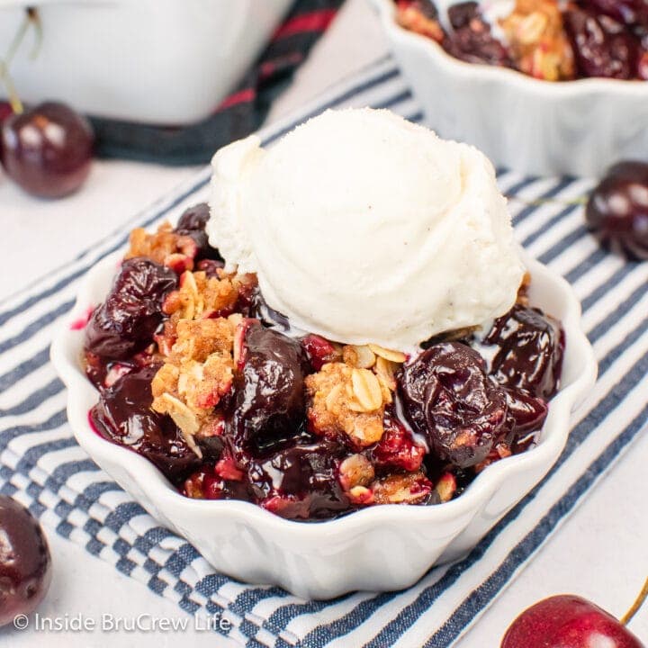 Two white bowls filled with a cherry and oat dessert.