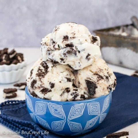 A blue bowl filled with scoops of homemade cookies and cream ice cream.