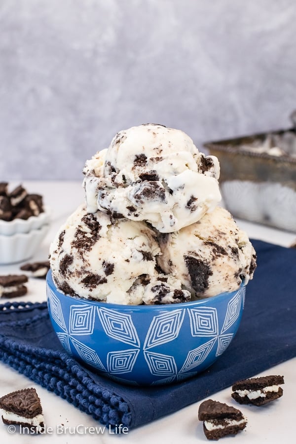 A blue bowl filled with scoops of cookies n cream ice cream.